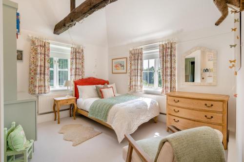 a bedroom with a bed and a dresser and windows at 7 Bed in Henley-on-Thames oc-d29802 in Northend