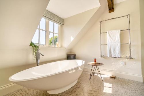 a white bathroom with a large tub and a window at 7 Bed in Henley-on-Thames oc-d29802 in Northend