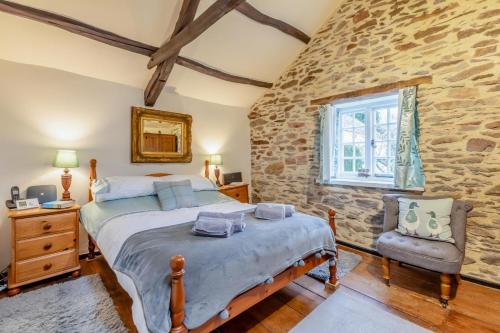 a bedroom with a bed and a stone wall at 1 Bed in Dulverton oc-l30886 in Dulverton