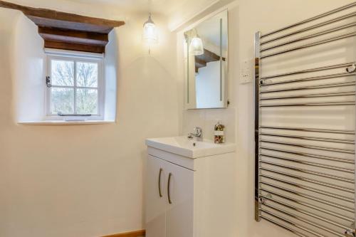 a bathroom with a sink and a mirror and a window at 1 Bed in Dulverton oc-l30886 in Dulverton