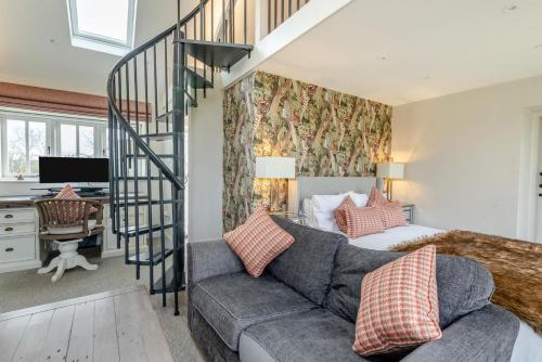 a living room with a couch and a spiral staircase at 5 Bed in Haceby oc-c31061 in Haceby