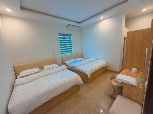a bedroom with two beds and a window at Tay Bac Hotel in Mộc Châu