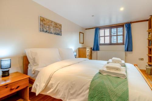 a bedroom with a white bed and a wooden desk at 1 Bed in Dorstone oc-c31765 in Dorstone