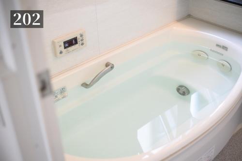 a bathroom with a tub with a sink at Shibuya City House 渋谷シティハウス in Tokyo