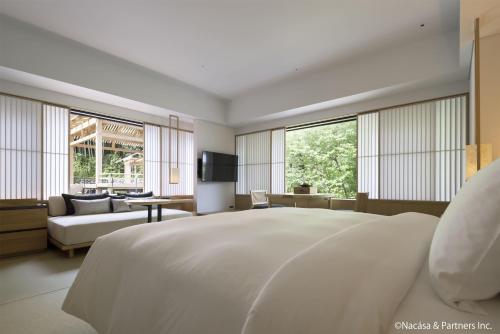 a white bedroom with a large bed and a couch at Banyan Tree Higashiyama Kyoto in Kyoto
