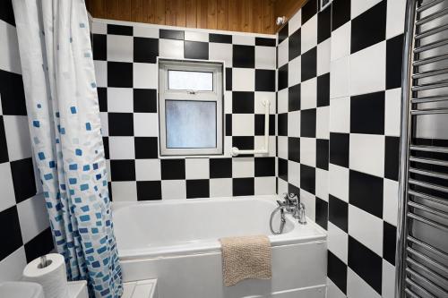 a bathroom with a black and white checkered wall at 4-Bed House in Enfield- Sleeps 8- Private garden in Enfield
