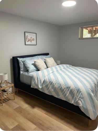a bedroom with a bed with blue and white stripes at Cozynest in Moncton