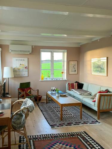 a living room with a couch and a table at Charming Farmhouse With Views On Møn in Borre