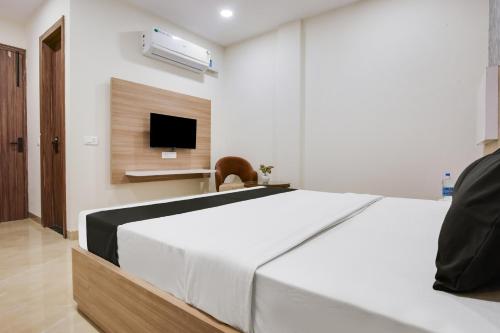 a bedroom with a large white bed and a tv at Heritage Villa in Ludhiana