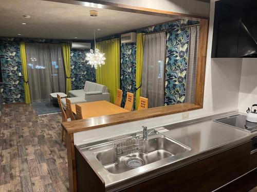 a kitchen with a sink and a living room at 安全な個室貸切に広々した共用スペースの喜久屋コテージクレア in Yamanakako