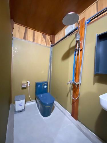 a bathroom with a blue toilet and a sink at Nui Tuong Village Stay in Tân Phú