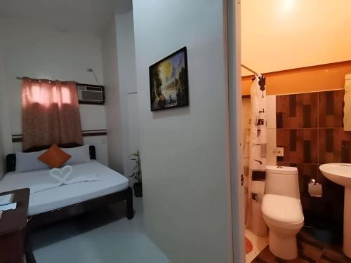 a small bathroom with a bed and a toilet at St. John Island View Pensionne in El Nido