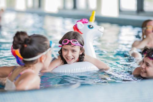 a group of children playing in a swimming pool at Staybridge Suites Detroit Woodhaven by IHG in Woodhaven