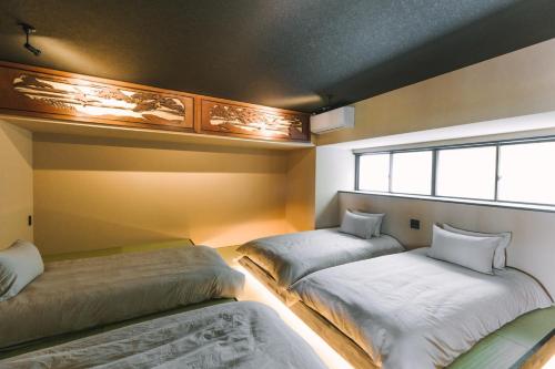 a bedroom with two beds and a window at SAUNA&STAY MUNI 桜島 in Kagoshima