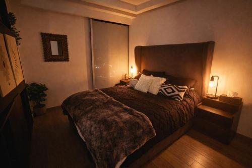 a bedroom with a large bed with two lamps at Cielito Lindo Boutique Studio in Chapultepec in Guadalajara