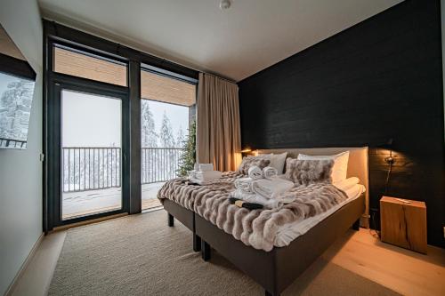 a bedroom with a large bed with a large window at Fjällen Aurora Luxe Chalet Ski-in Ski-out by Aavalevi in Levi