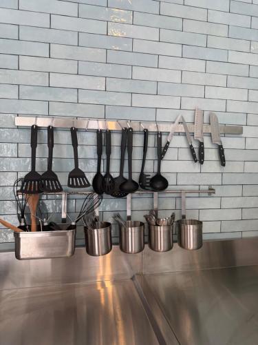 a bunch of cooking utensils hanging on a wall at Summer House Magnetic Island in Arcadia