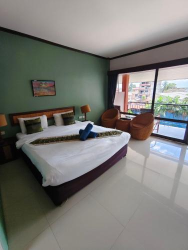 a bedroom with a large bed and a balcony at Grand Thai House Resort Lamai in Lamai