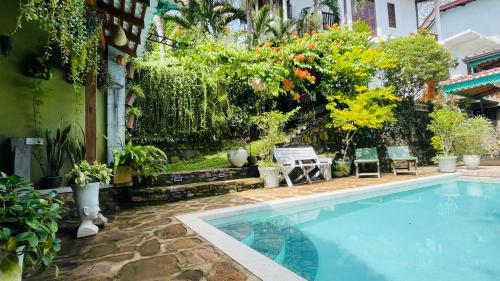 a swimming pool in a yard with plants at Bouganvilla House in Unawatuna