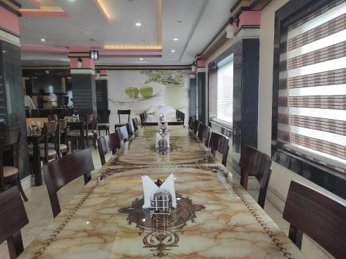 a long dining room with a long table and chairs at Hotel Rising Sun in Bacha