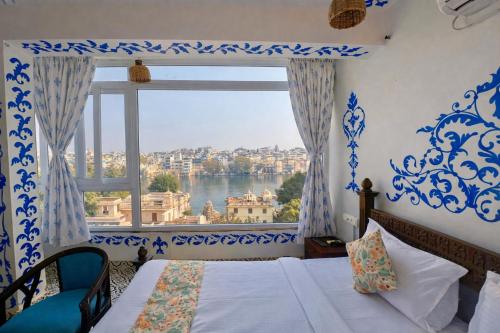 a bedroom with a window with a view of the water at Storica Stays Panorama Haveli Udaipur in Udaipur