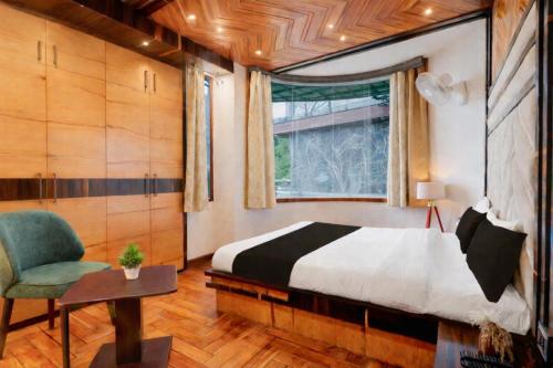 a bedroom with a bed and a chair and a window at Fun Flock Stay in Mussoorie