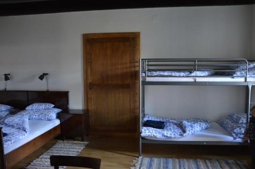 a room with three bunk beds and a door at Bagolyvár Fogadó- Újfalusy Márton Vendégház in Zirc