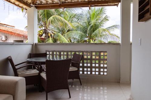 a patio with a table and chairs and palm trees at Pousada Flor do Sol in Fortaleza