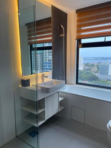 a bathroom with a sink and a tub and a window at Suasana Johor Bahru City Centre by SummerSpace in Johor Bahru