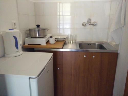 a small kitchen with a sink and a microwave at Giannis Hotel in Paralia Katerinis