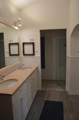 a bathroom with two sinks and a large mirror at Bagolyvár Fogadó- Újfalusy Márton Vendégház in Zirc