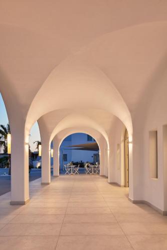 an archway in a building with a view of the ocean at Aqua Blue Beach Hotel in Perissa