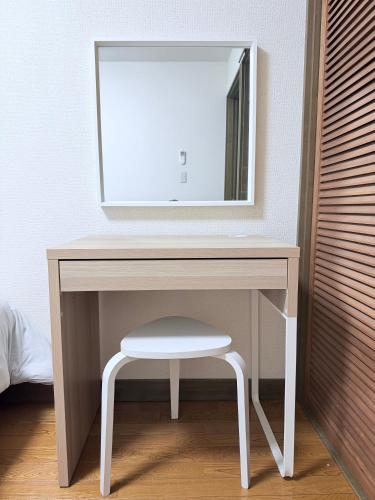 a white dressing table with a stool and a mirror at Cozy Family Room 305 in Matsumoto
