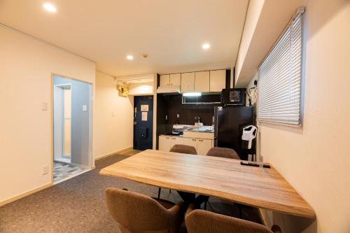 a kitchen and dining room with a wooden table and chairs at StaySpring HARUYOSHI in Fukuoka