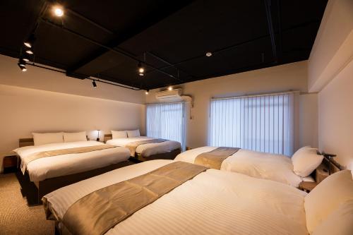 a room with four beds in a room at StaySpring HARUYOSHI in Fukuoka