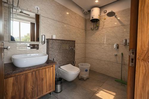a bathroom with a sink and a toilet at Hotel Vaidik Ganga in Rishīkesh