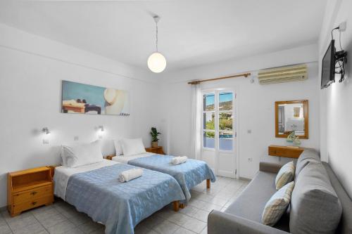 una sala de estar con dos camas y un sofá en Seample studios, en Chrissi Akti