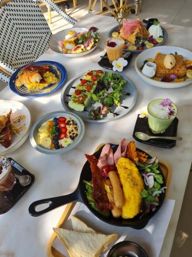 a table with many plates of food on it at Treevana Club Chiangmai in Chiang Mai