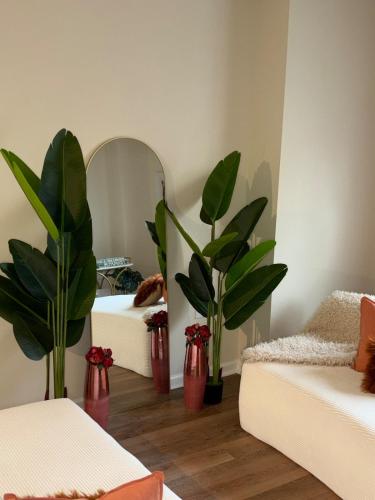 a living room with two red vases with plants in it at Luxury, Chic, Apt with Game Room, Movie Theatre, & 24hr Gym in Rockville