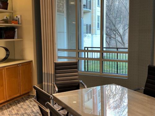 a conference room with a table and chairs and a window at Luxury, Chic, Apt with Game Room, Movie Theatre, & 24hr Gym in Rockville