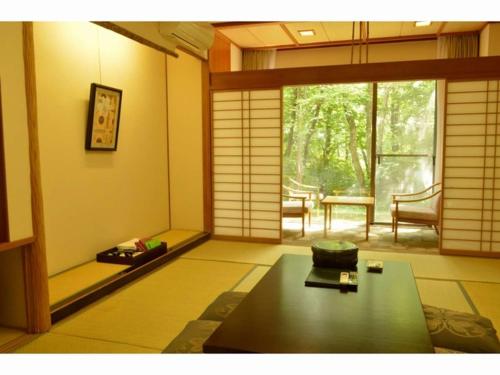 a room with a room with a table and a window at Blancvert Nasu Onsen Hotel in Nasu