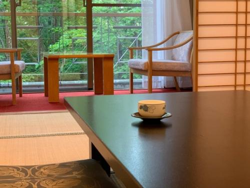a coffee cup sitting on a table in a room at Blancvert Nasu Onsen Hotel in Nasu