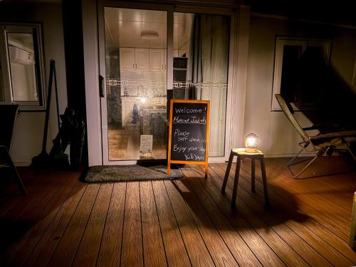 a room with a chalkboard sign in front of a door at AAK cabin - standalone riverfront cabin in Malanda