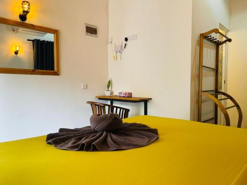 a towel sitting on top of a yellow table at Hasara Homestay in Dickwella