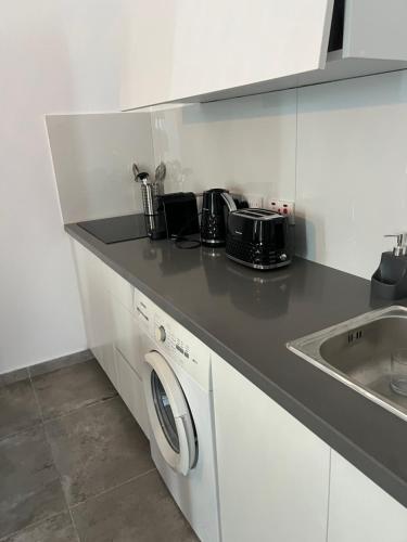 a kitchen with a washing machine and a sink at Sea view Appartment in Larnaca