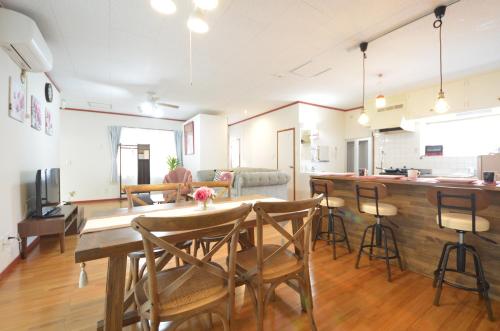 a kitchen and living room with a table and chairs at Sobe House in Yomitanson in Yomitan