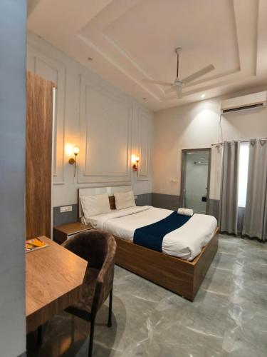 a bedroom with a bed and a table and a desk at Hotel Indo Tiger by RawatHospitality in Tembhuida