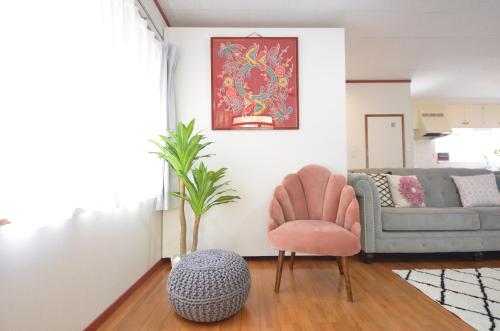 a living room with a chair and a couch at Sobe House in Yomitanson in Yomitan