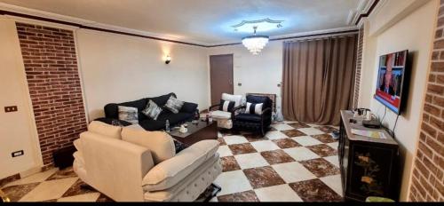 a living room with a couch and chairs in it at Sheraton Apartment شقة الشيراتون in Cairo