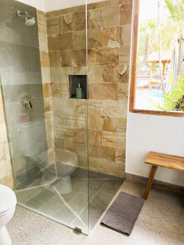 a shower with a glass door in a bathroom at Kubu Elsa Bali in Lovina